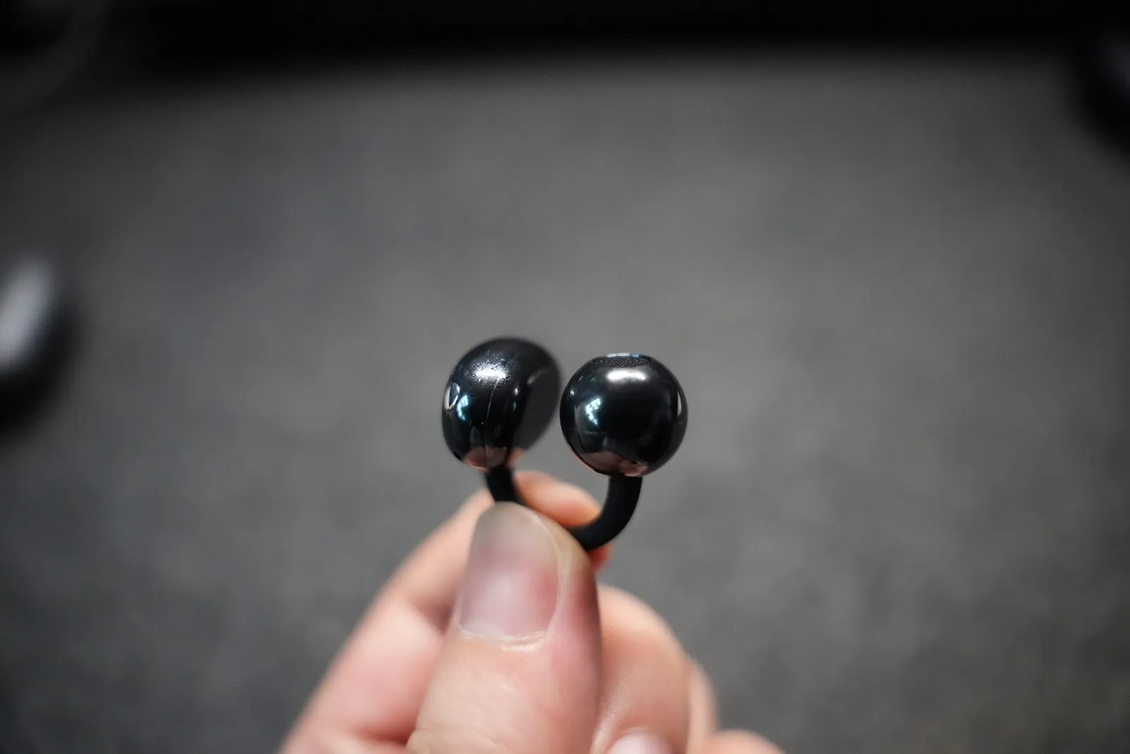 Holding a single HUAWEI FreeClip 2, featuring a sleek, symmetrical geometric design
